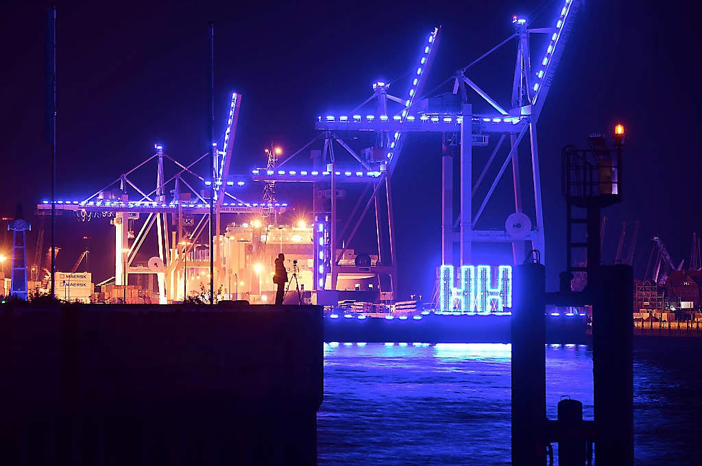 Beleuchtete Kräne am Hafen bei Nacht